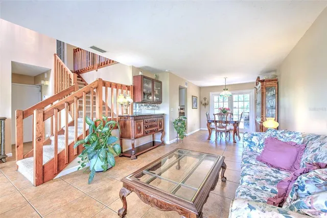 a dining room with furniture a chandelier and wooden floor