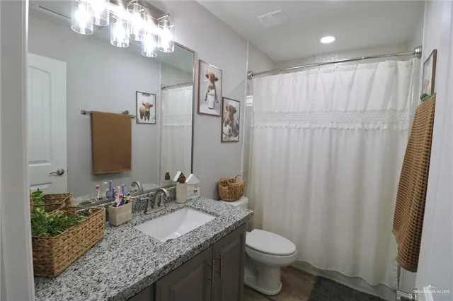a bathroom with a granite countertop sink toilet and shower