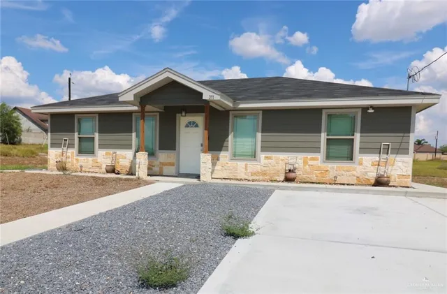 a front view of a house with yard and parking