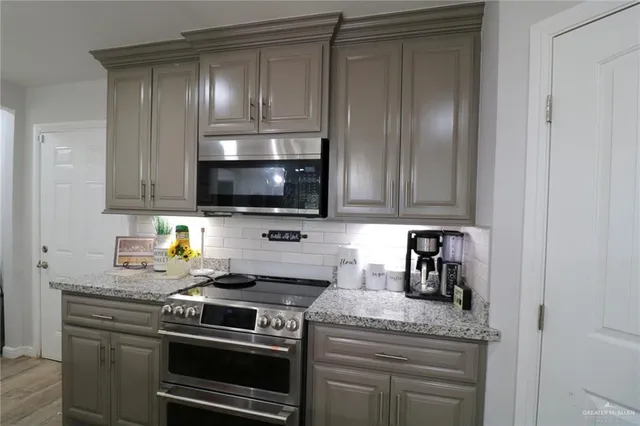 a kitchen with granite countertop a stove and a microwave