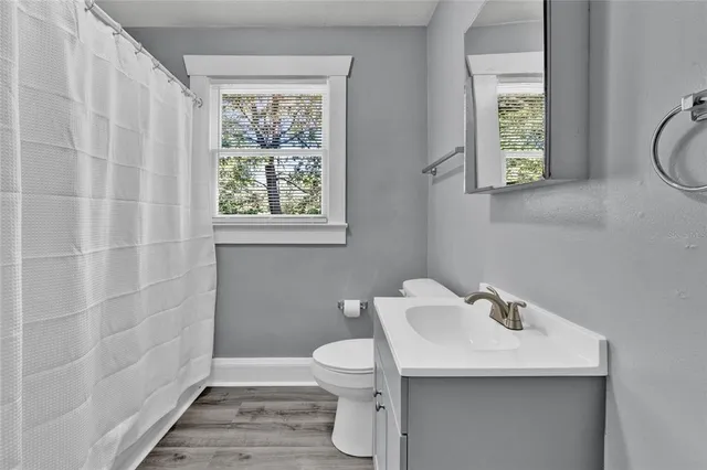 a bathroom with a toilet a sink and a window