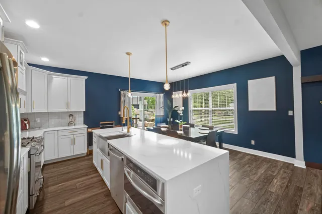 a large kitchen with kitchen island a large counter space a sink appliances and cabinets