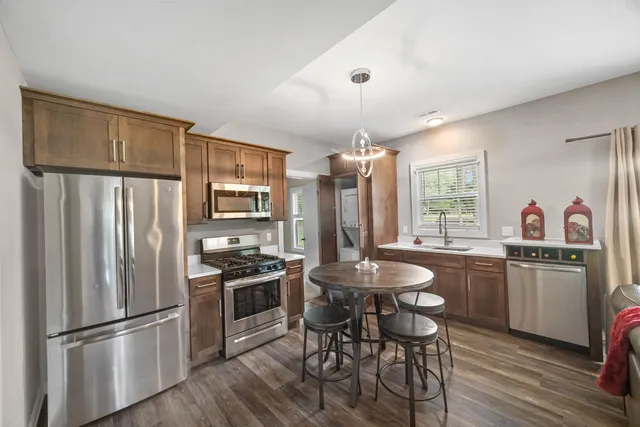 a kitchen with refrigerator cabinets dining table and chairs
