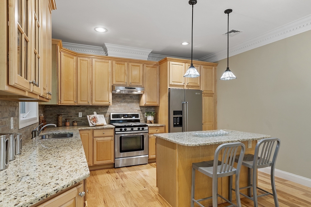 139 Prospect Street, Unit 5 Acton, MA 01720 - Photo 12 of 34 a kitchen with stainless steel appliances granite countertop a stove a sink refrigerator and a wooden cabinets