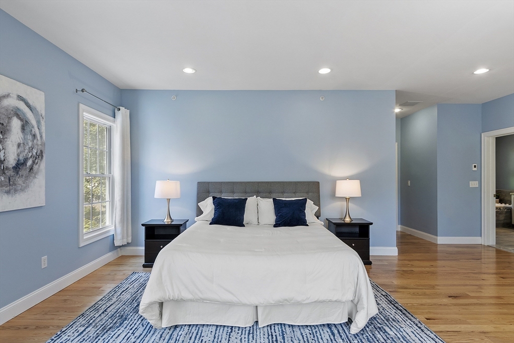 139 Prospect Street, Unit 5 Acton, MA 01720 - Photo 22 of 34 a spacious bedroom with a bed and wooden floor