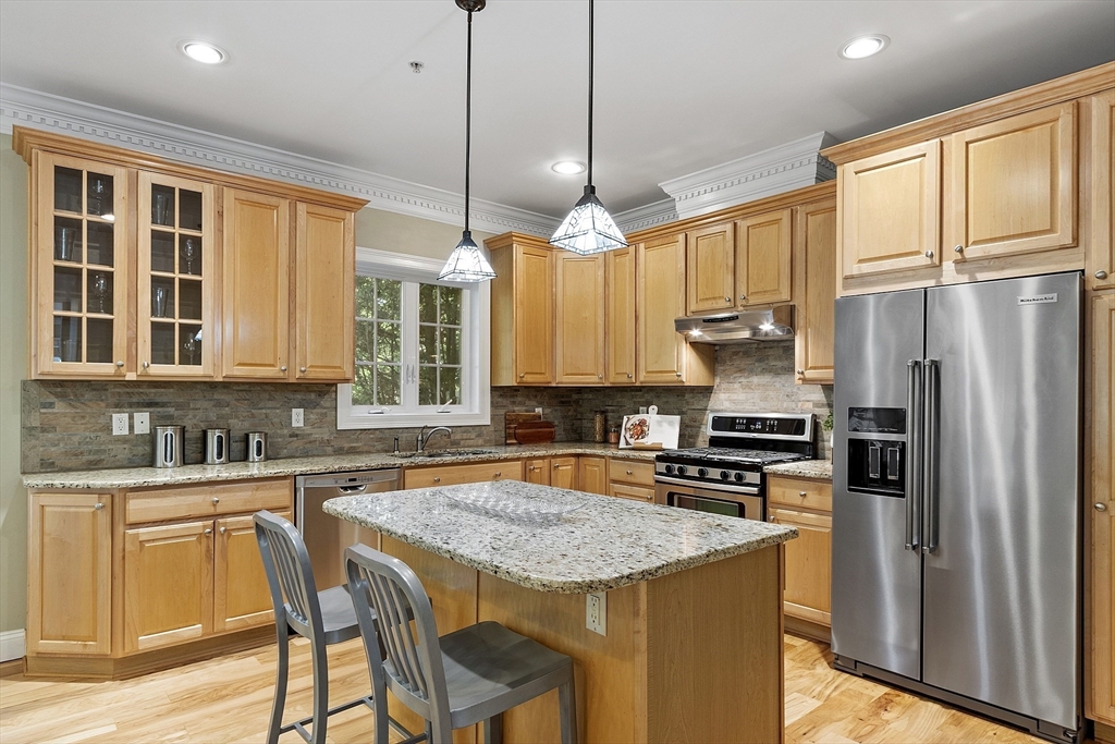 139 Prospect Street, Unit 5 Acton, MA 01720 - Photo 10 of 34 a kitchen with stainless steel appliances granite countertop a stove a sink a refrigerator a center island and a cabinets