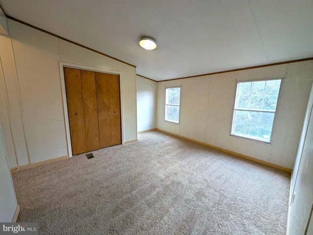 an empty room with windows and closet