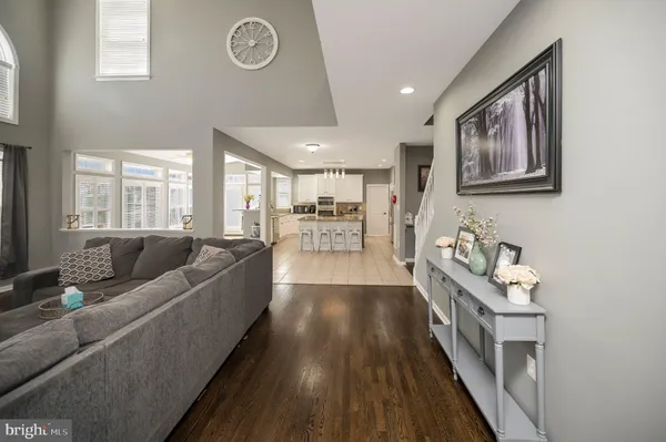 a kitchen with a stove a sink a refrigerator and white cabinets with wooden floor