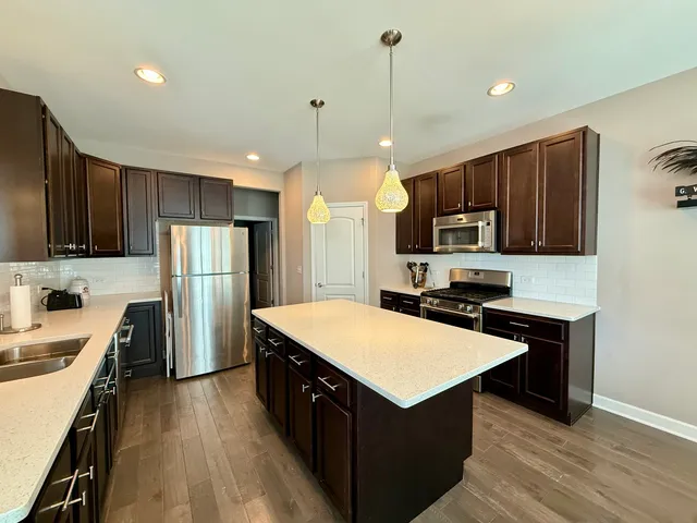 a kitchen with refrigerator cabinets and wooden floor