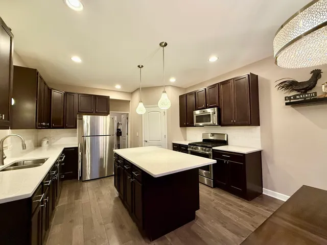 a kitchen with refrigerator cabinets and wooden floor
