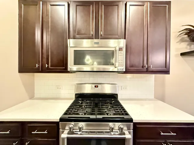 a kitchen with granite countertop a stove and a microwave