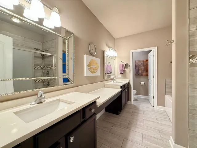 a large bathroom with a double vanity sink a mirror and a shower