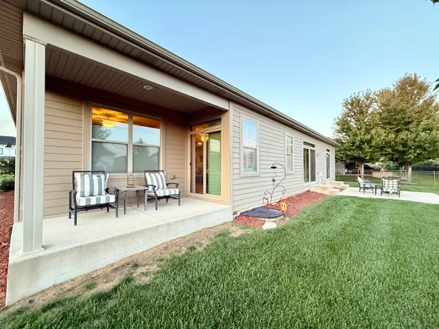 a view of house with backyard and outdoor seating