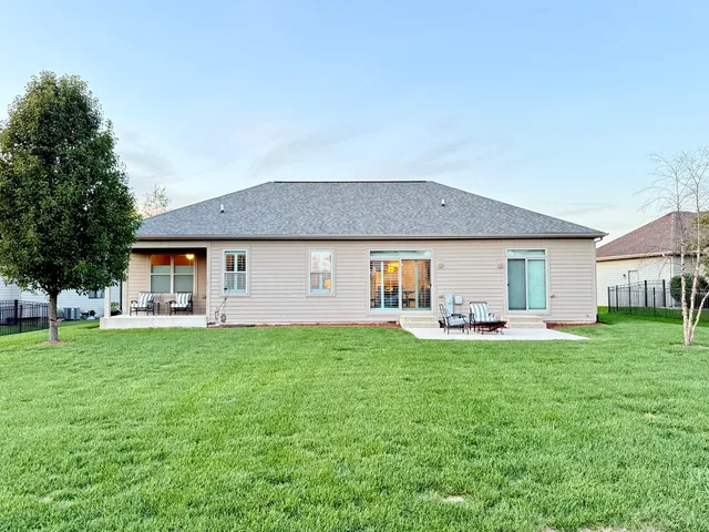 a front view of a house with a garden and trees