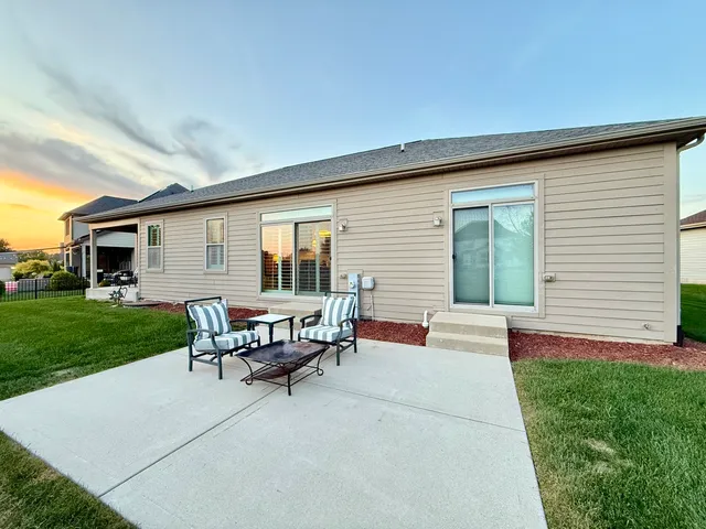 a view of a house with a backyard and sitting area