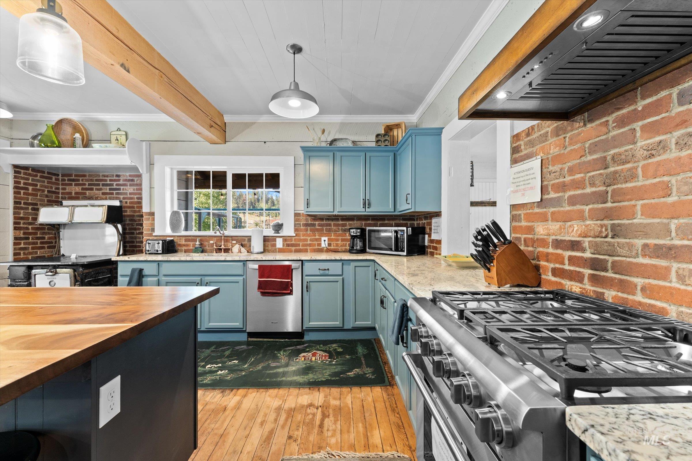 315 South Middlefork Road Garden Valley, ID 83622 - Photo 16 of 49 Kitchen with ornamental molding, exhaust hood, light wood-style flooring, wooden counters, and stainless steel appliances