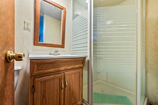 a bathroom with a sink a mirror and shower