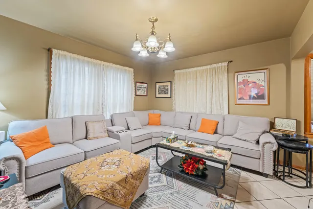 a living room with furniture and a chandelier