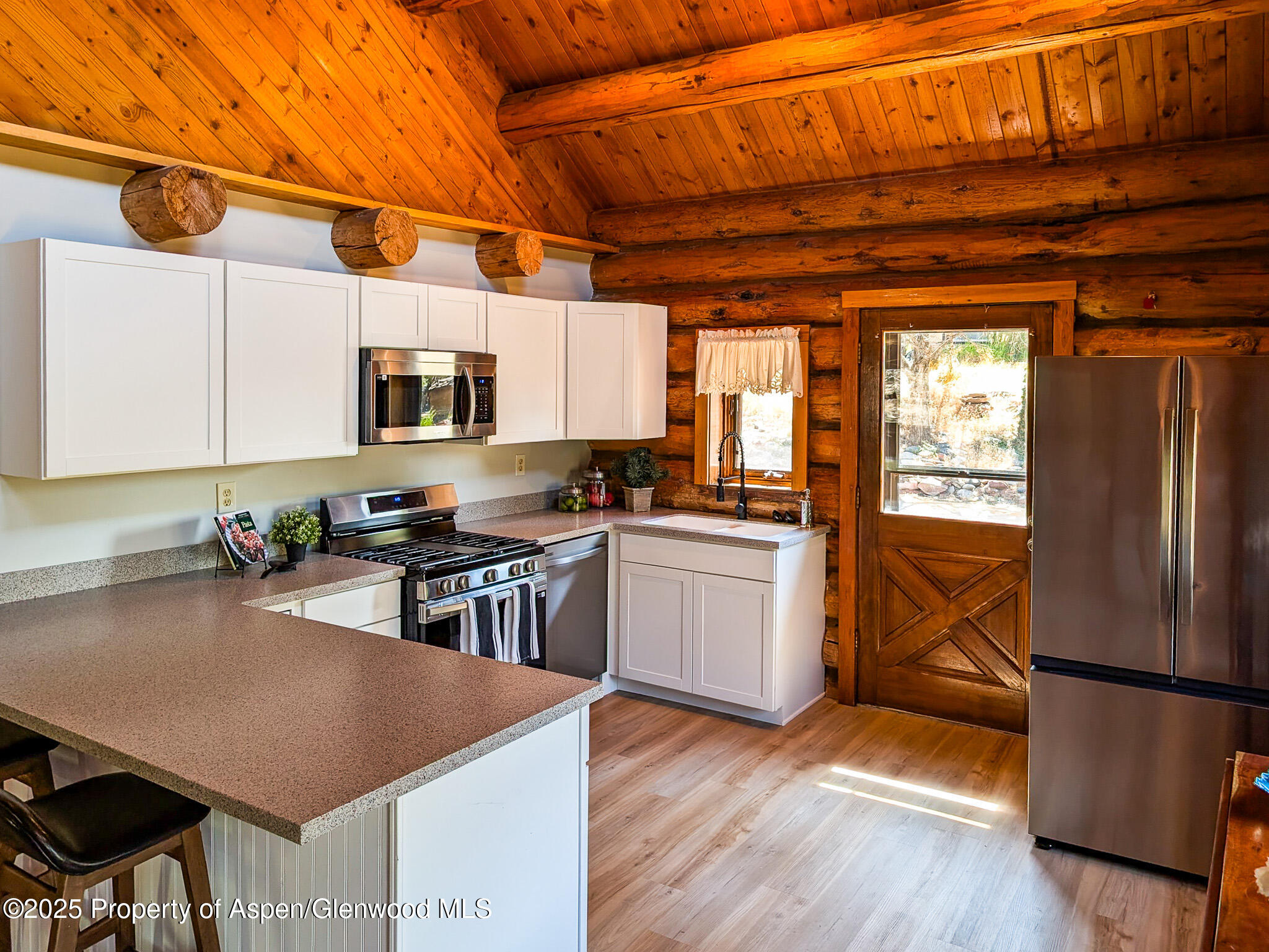 96 Apache Drive New Castle, CO 81647 - Photo 6 of 34 a kitchen with stainless steel appliances granite countertop a refrigerator a sink a stove and white cabinets