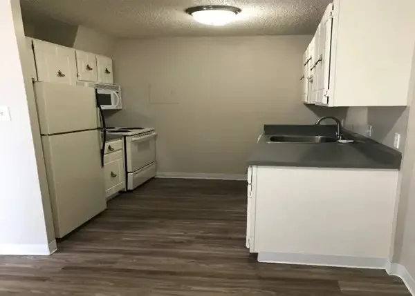 a kitchen with a refrigerator and a stove