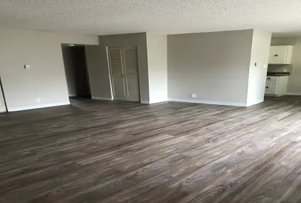 a view of an empty room with wooden floor