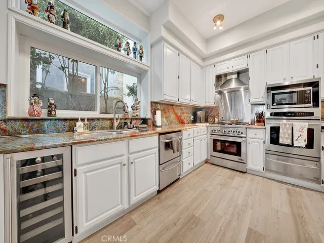 a kitchen with white cabinets stainless steel appliances and sink