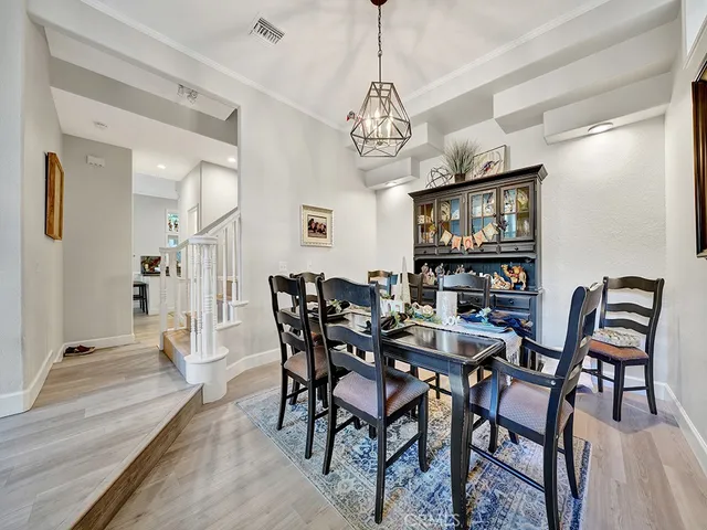 a view of a dining room with furniture a chandelier and wooden floor