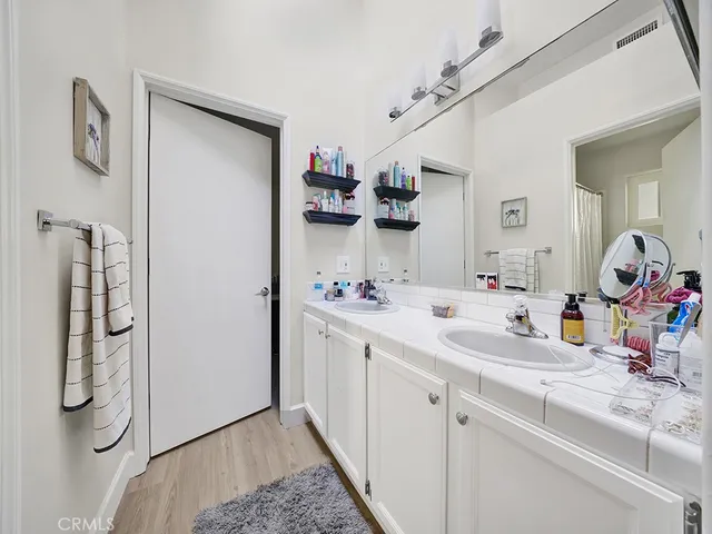 a bathroom with a sink and mirror with shower