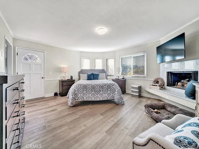 a spacious bedroom with a bed a couch and a flat screen television