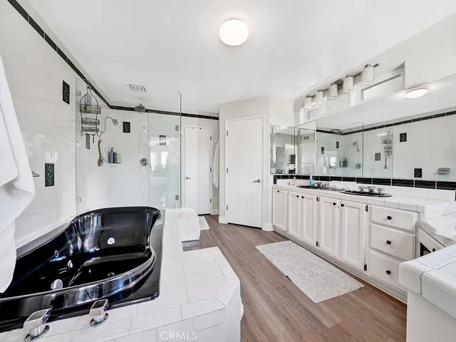 a living room with white furniture and wooden floor