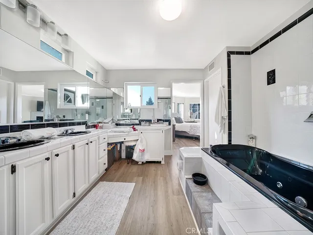 a large white kitchen with a lot of white cabinets and stainless steel appliances