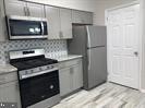 2503 Stokes Road Mount Laurel, NJ 08054 - Photo 4 of 22 a kitchen with stainless steel appliances wooden cabinets and a stove top oven