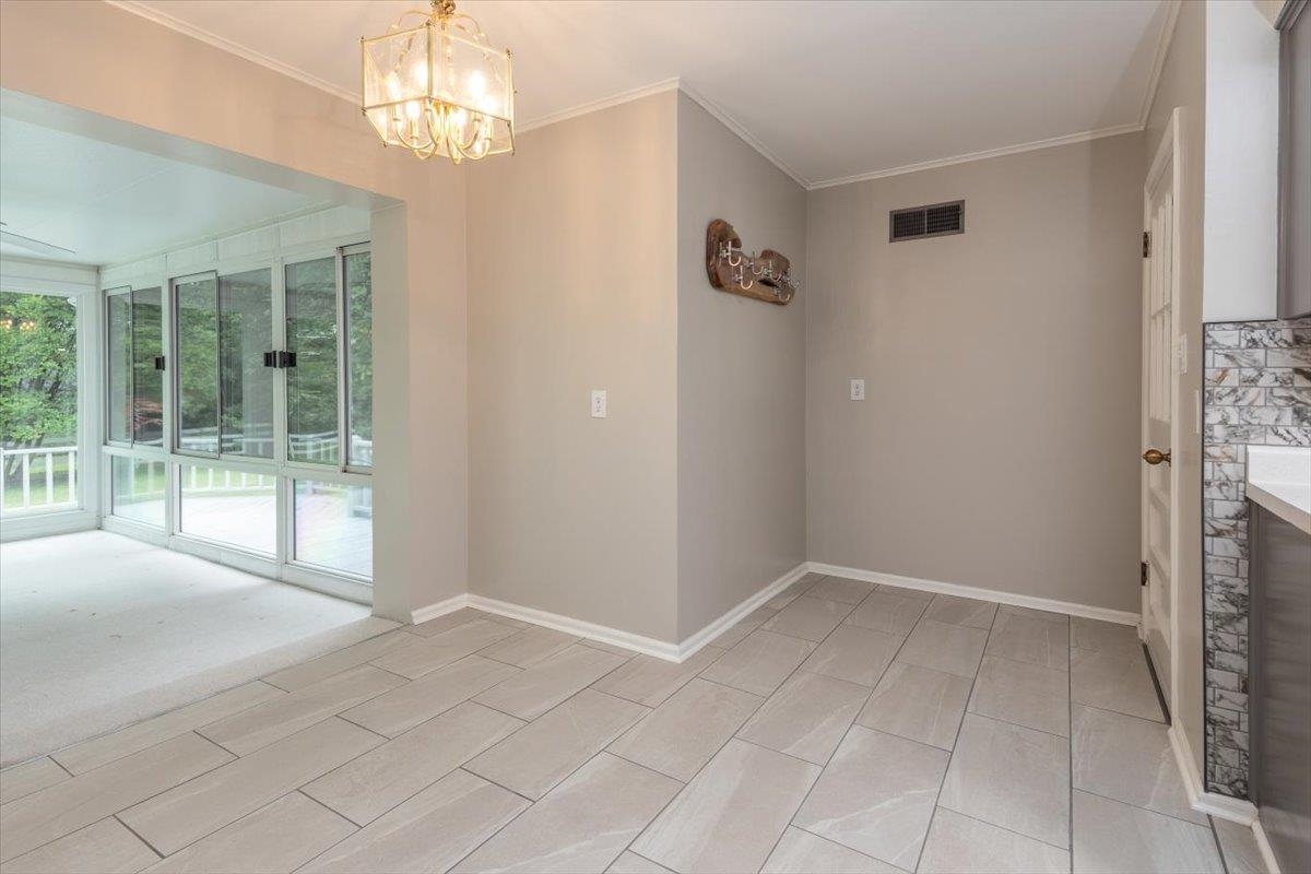 670 Peterson Lake Road Collierville, TN 38017 - Photo 9 of 37 Light grey tile flooring with a decorative chandelier