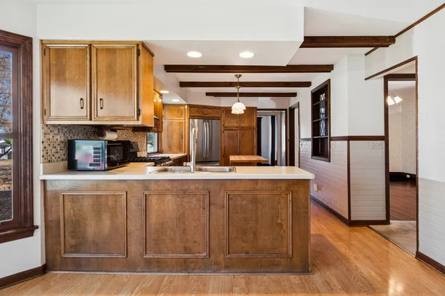 a kitchen with stainless steel appliances granite countertop a refrigerator a sink and a stove