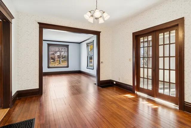 a view of an empty room with window and wooden floor