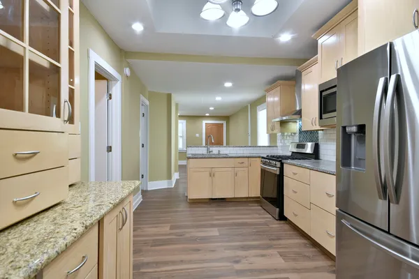 a kitchen with stainless steel appliances granite countertop a refrigerator microwave and stove
