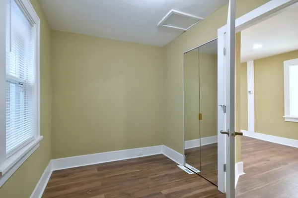 a small space with wooden floor and a window