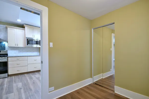 a view of a small space with wooden floor and a window