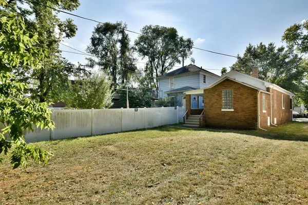 a view of a house with backyard and trees