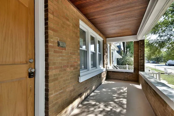 a view of a porch with furniture and floor to ceiling window