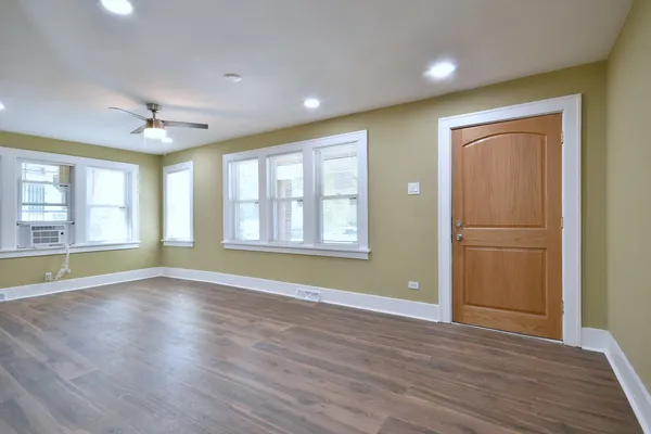 a view of an empty room with a window and fireplace