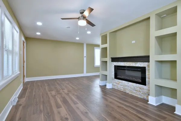 a view of empty room with wooden floor and fireplace