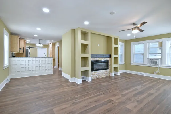 a view of empty room with wooden floor and fireplace