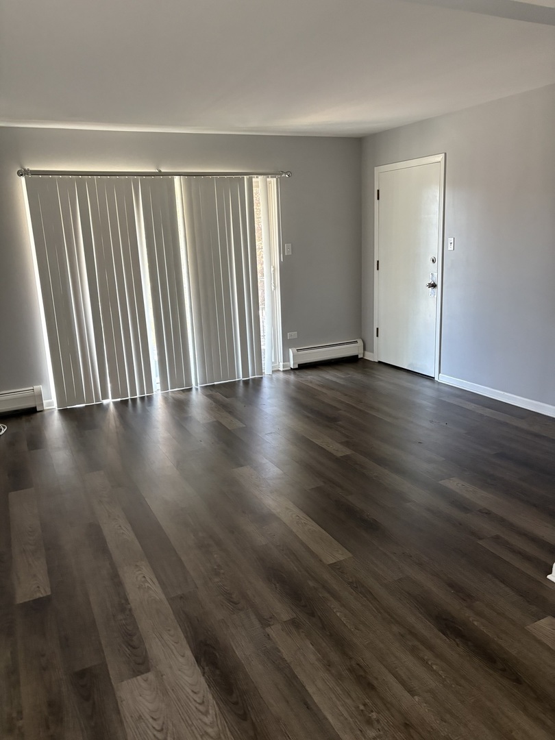 4521 Maple Avenue, Unit 2S Brookfield, IL 60513 - Photo 2 of 8 a view of an empty room with wooden floor and a window