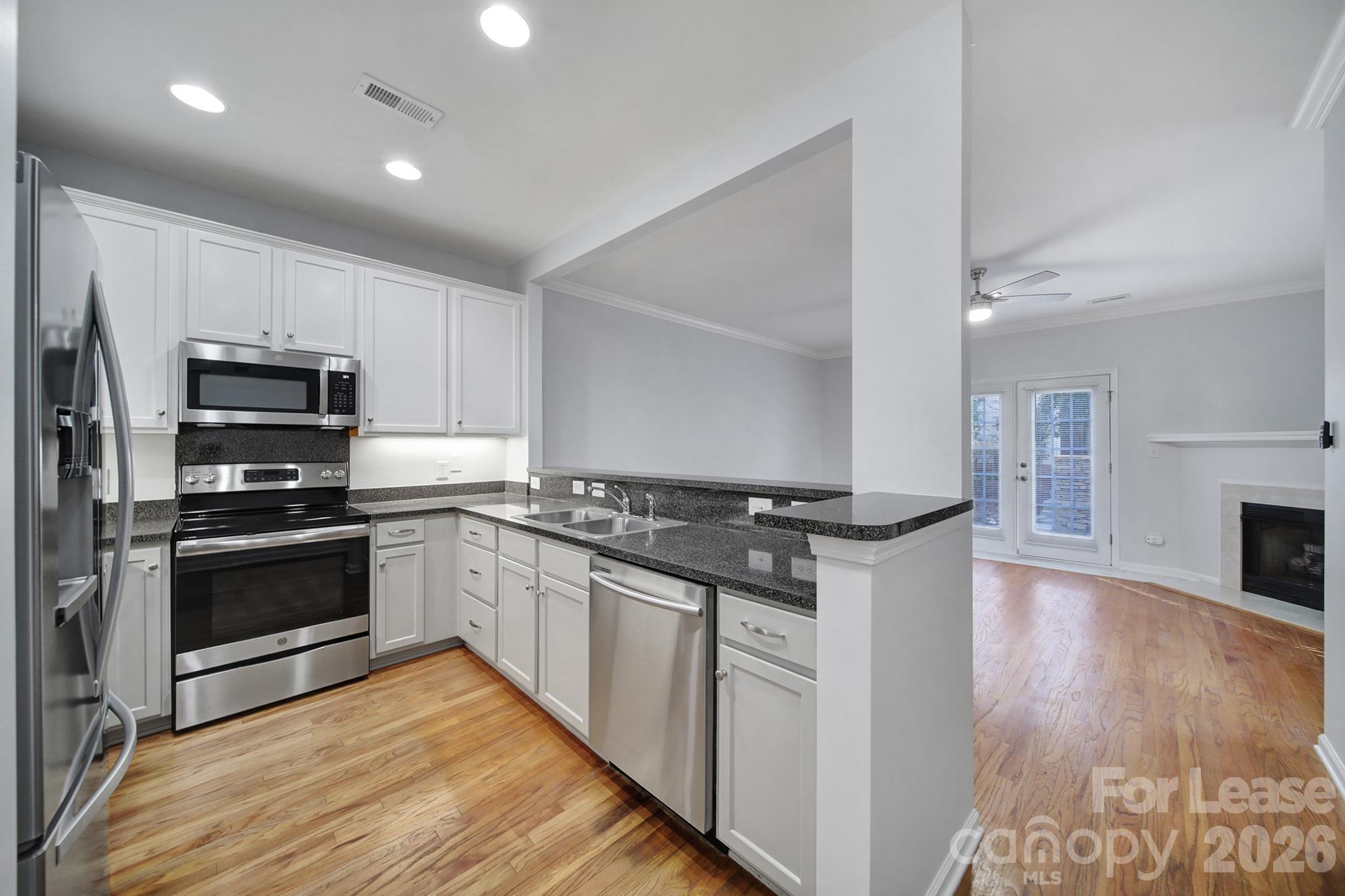 14844 Scothurst Lane Charlotte, NC 28277 - Photo 15 of 33 a kitchen with stainless steel appliances and wooden floor