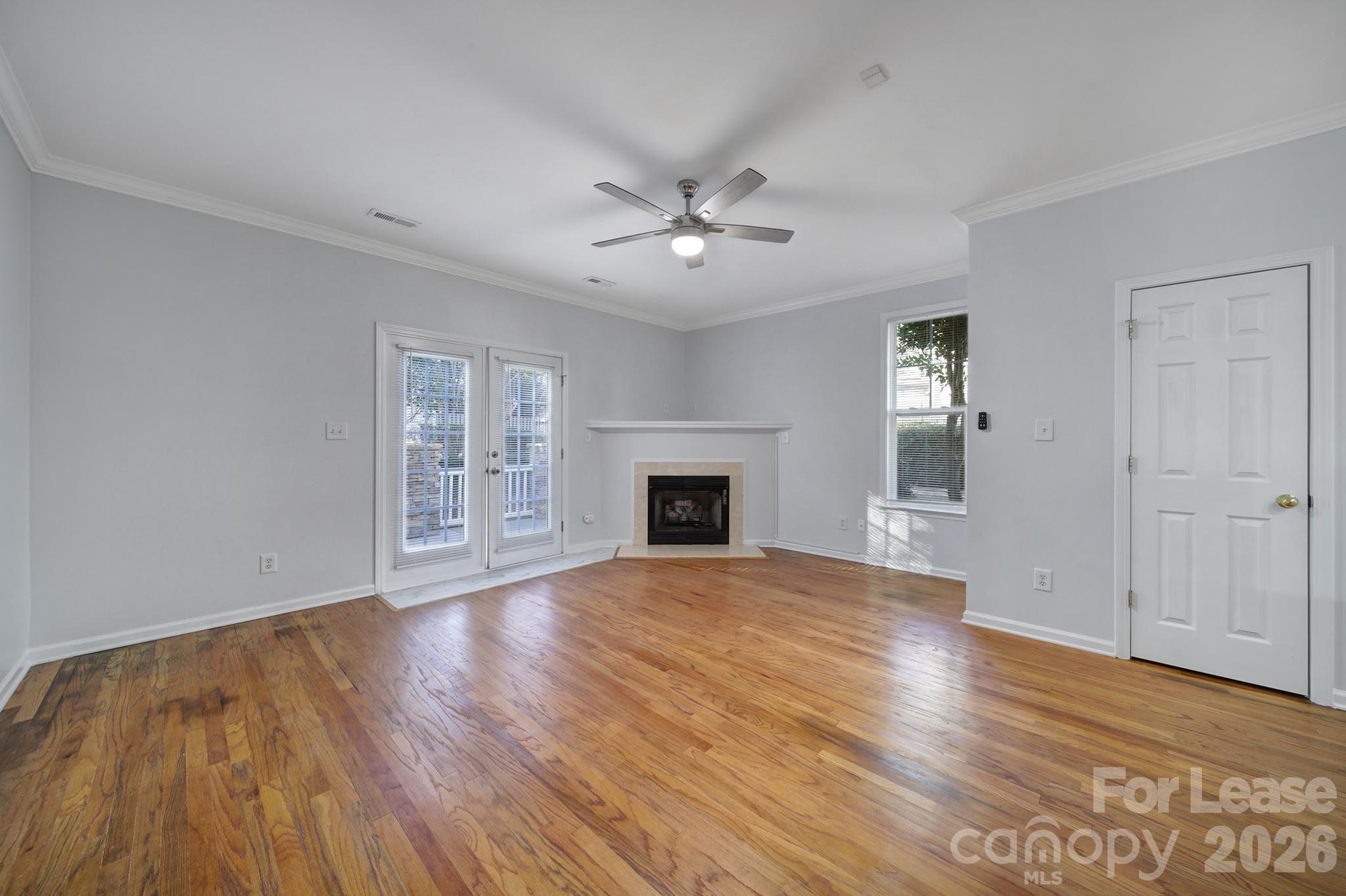 14844 Scothurst Lane Charlotte, NC 28277 - Photo 21 of 33 a view of an empty room with wooden floor fireplace and a window