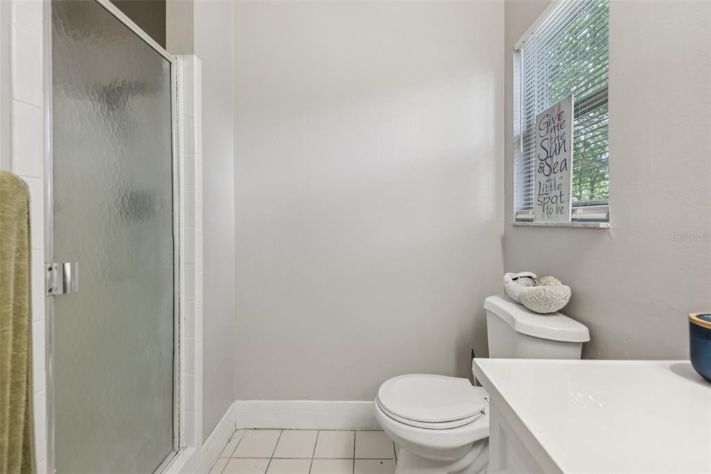 3 Silver Court Ocala, FL 34472 - Photo 12 of 25 a white toilet sitting next to a bathroom sink and vanity