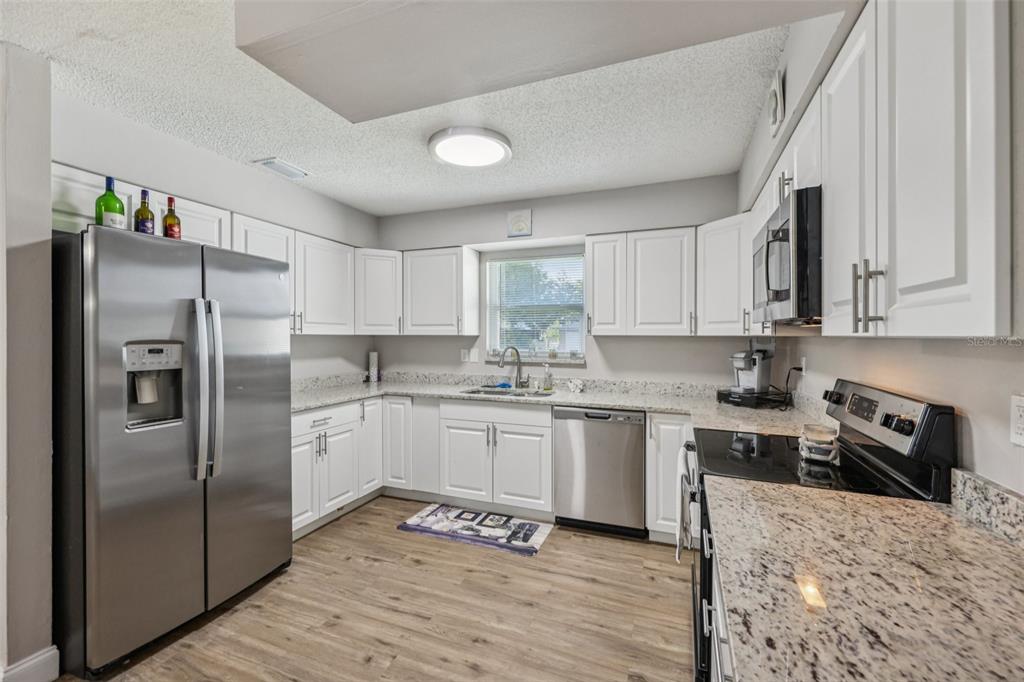 3 Silver Court Ocala, FL 34472 - Photo 6 of 25 a kitchen with granite countertop a refrigerator stove top oven and sink
