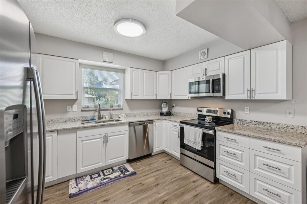 3 Silver Court Ocala, FL 34472 - Photo 7 of 25 a kitchen with stainless steel appliances granite countertop a sink a stove a refrigerator cabinets and a window