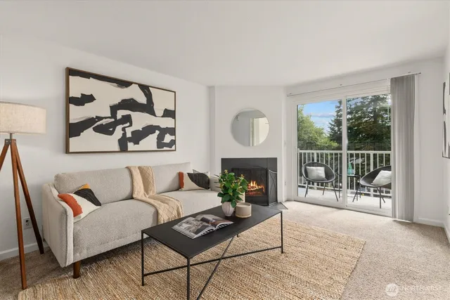 a living room with furniture a fireplace and a floor to ceiling window